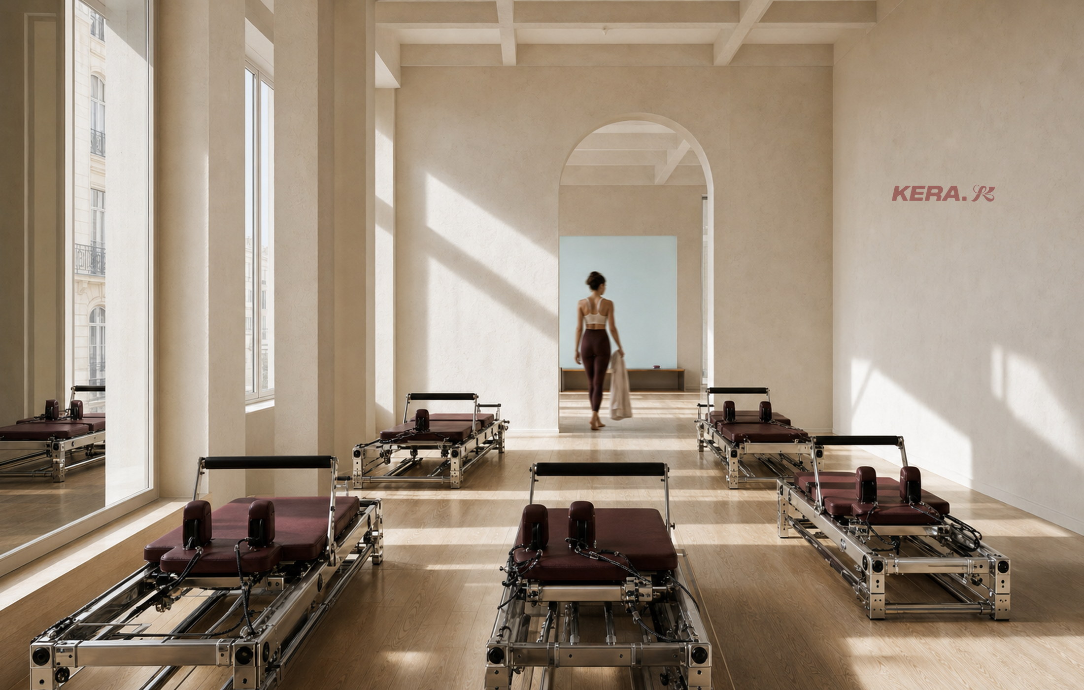 Studio KERA encadré de hautes fenêtres et d’arches, avec des rangées de reformers